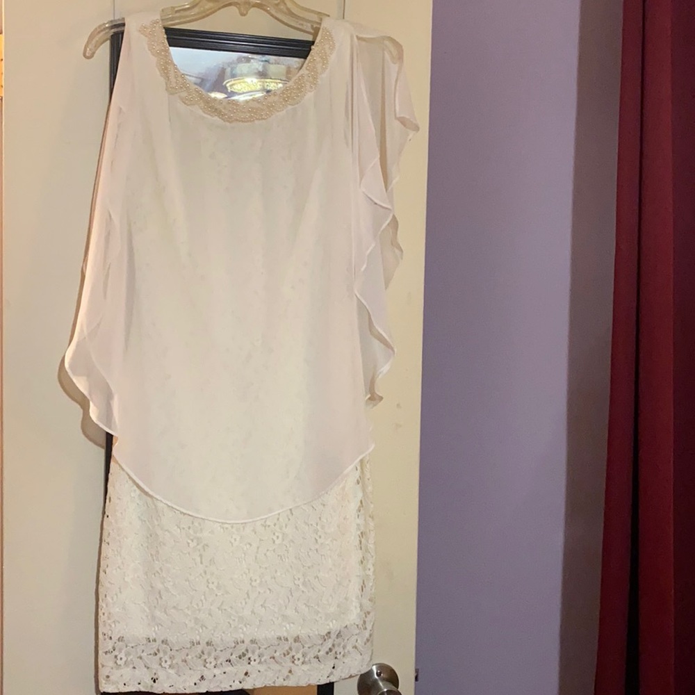 An Ivory dress with pearl on front with a veil